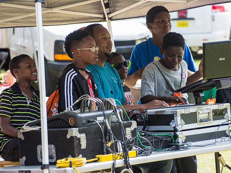 A man teaching kids how to use digital equipment